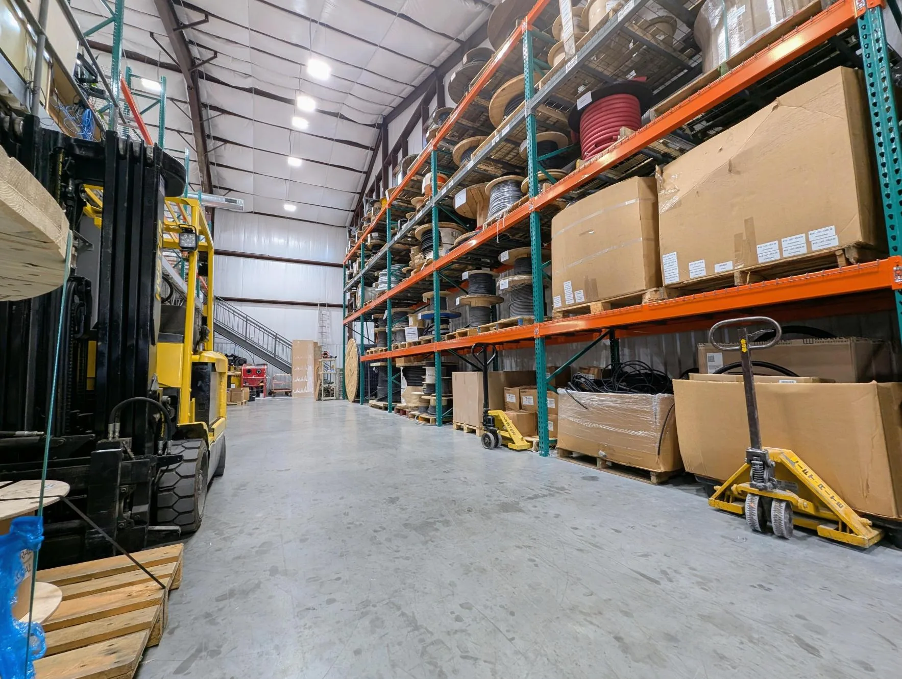 Eastern Connector inventory aisle with pallet racks, wire reels, and material handling equipment